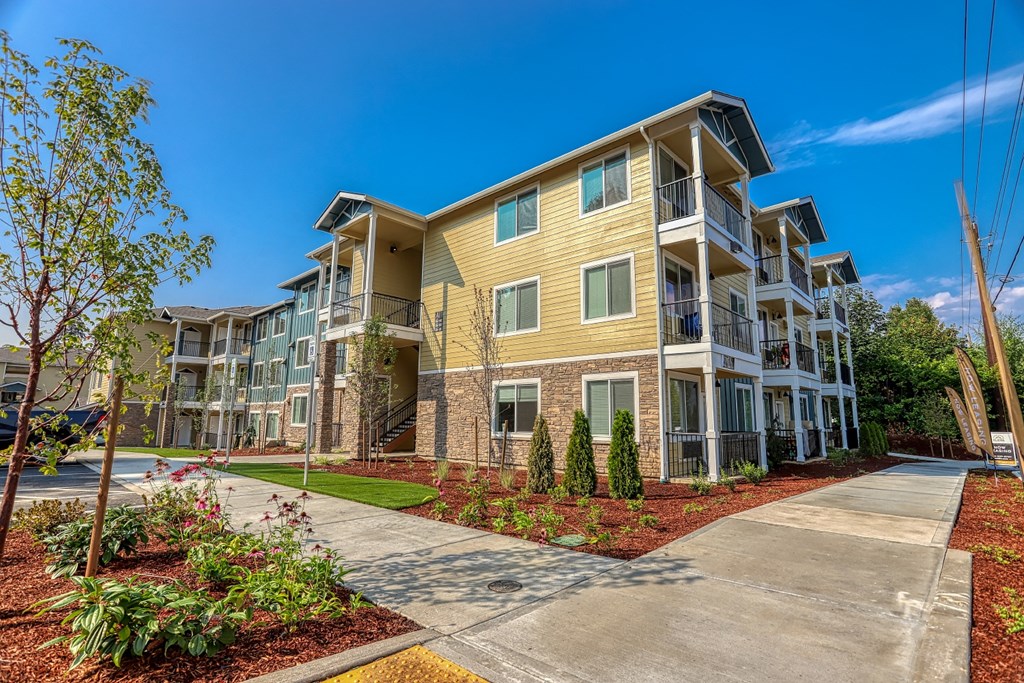 an apartment building with a sidewalk in front of it