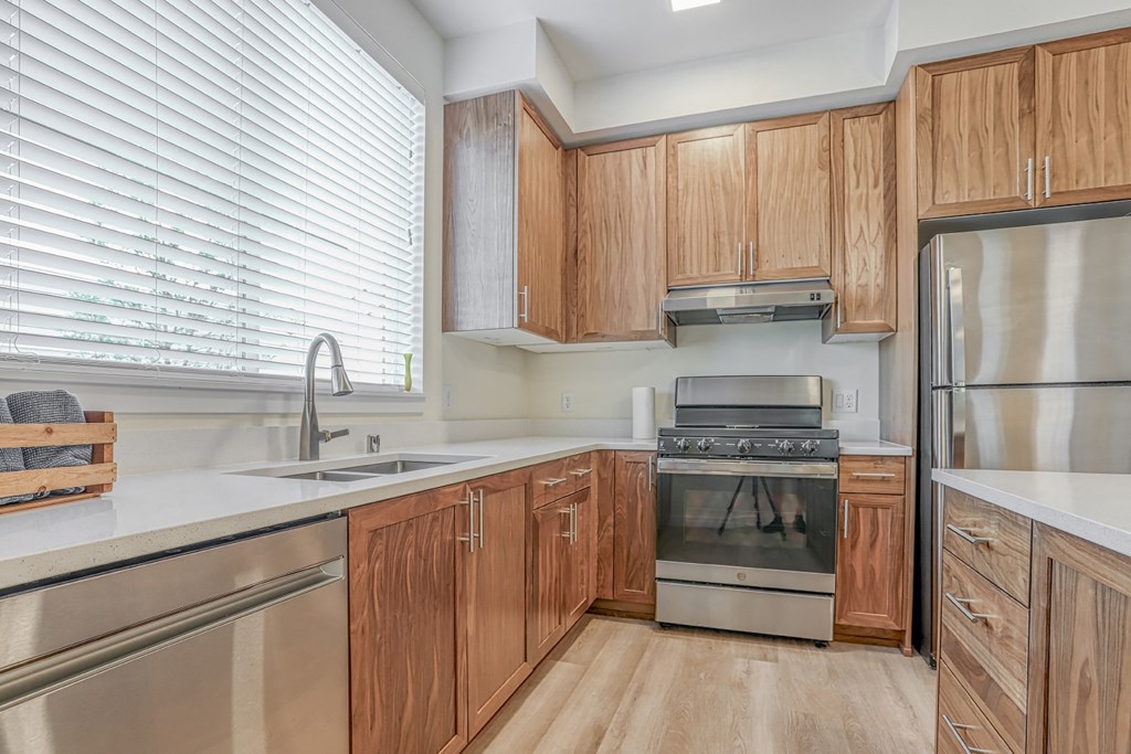 a kitchen with wooden cabinets and stainless steel appliances