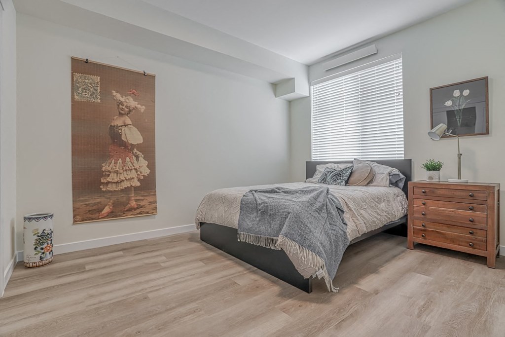 a bedroom with a bed and a dresser in a 555 waverly unit