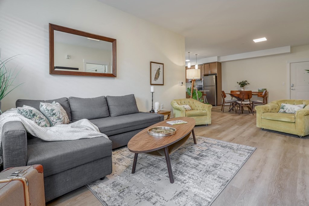 a living room with a gray couch and a yellow chair