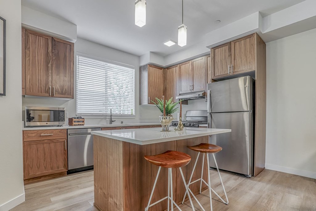 a kitchen with a large island with two stools in front of it