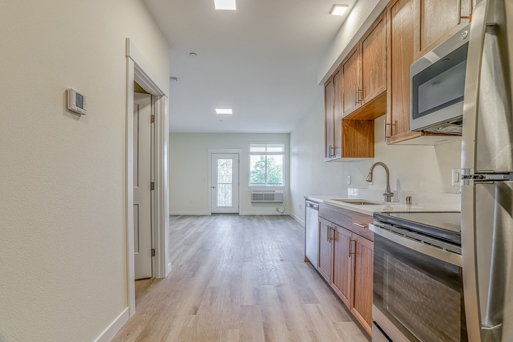 a kitchen and living room with wood floors and white walls