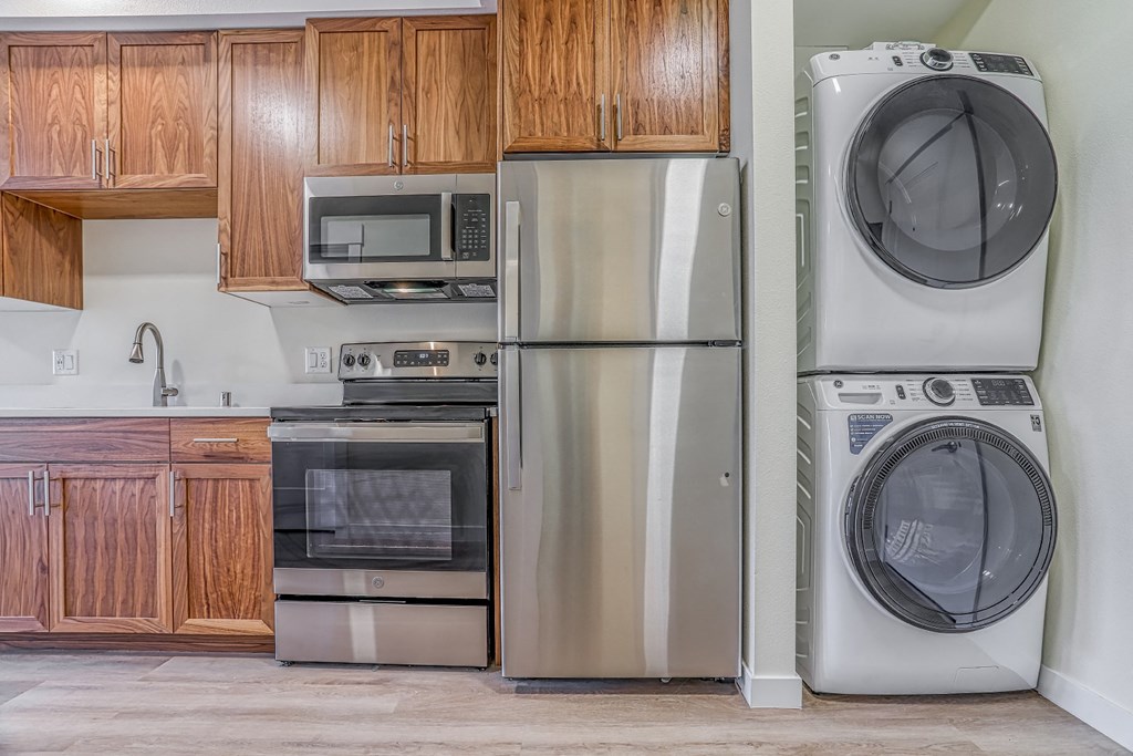 a kitchen with wood cabinets and stainless steel appliances