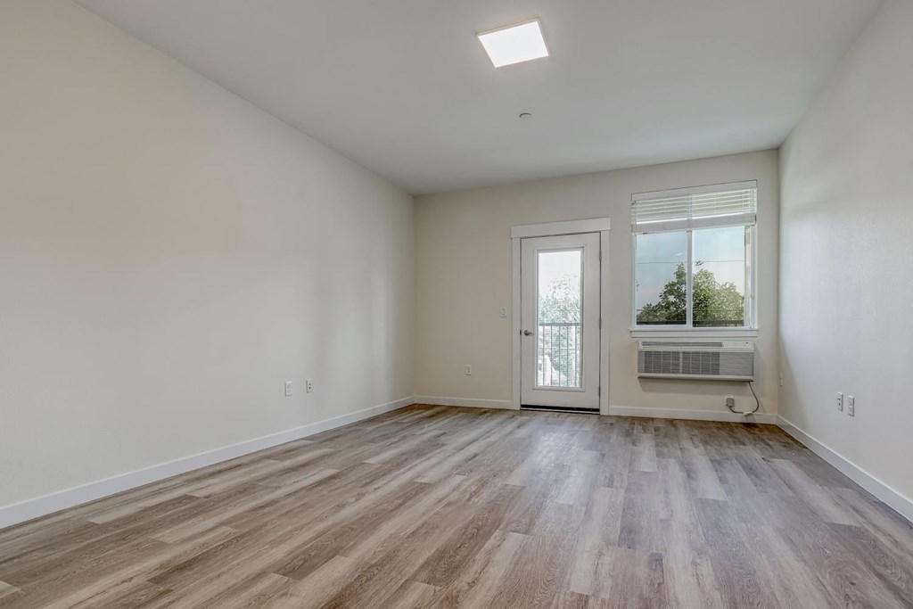 a bedroom with hardwood floors and white walls