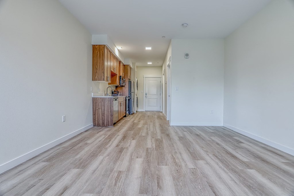 a kitchen and living room with hardwood floors and white walls