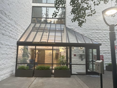 The Alaska House has a glass entrance and is lit by a street lamp.