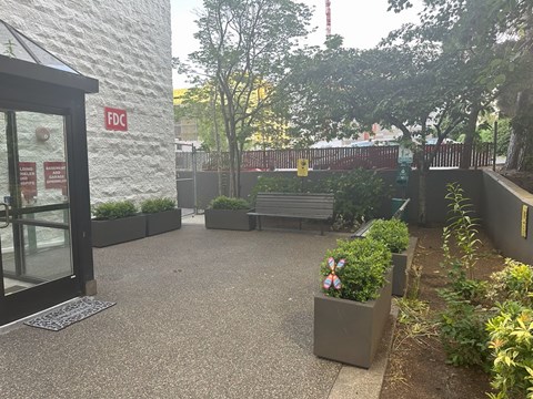 A courtyard with a bench and a planter with a pinwheel on it.