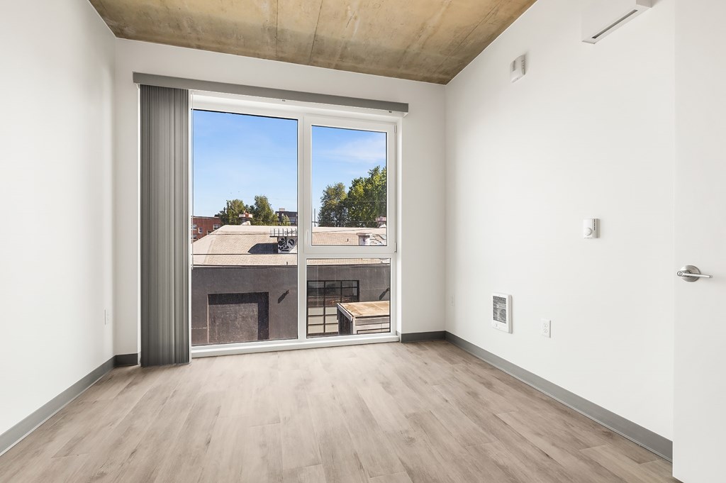 A room with a sliding glass door leading to a balcony.
