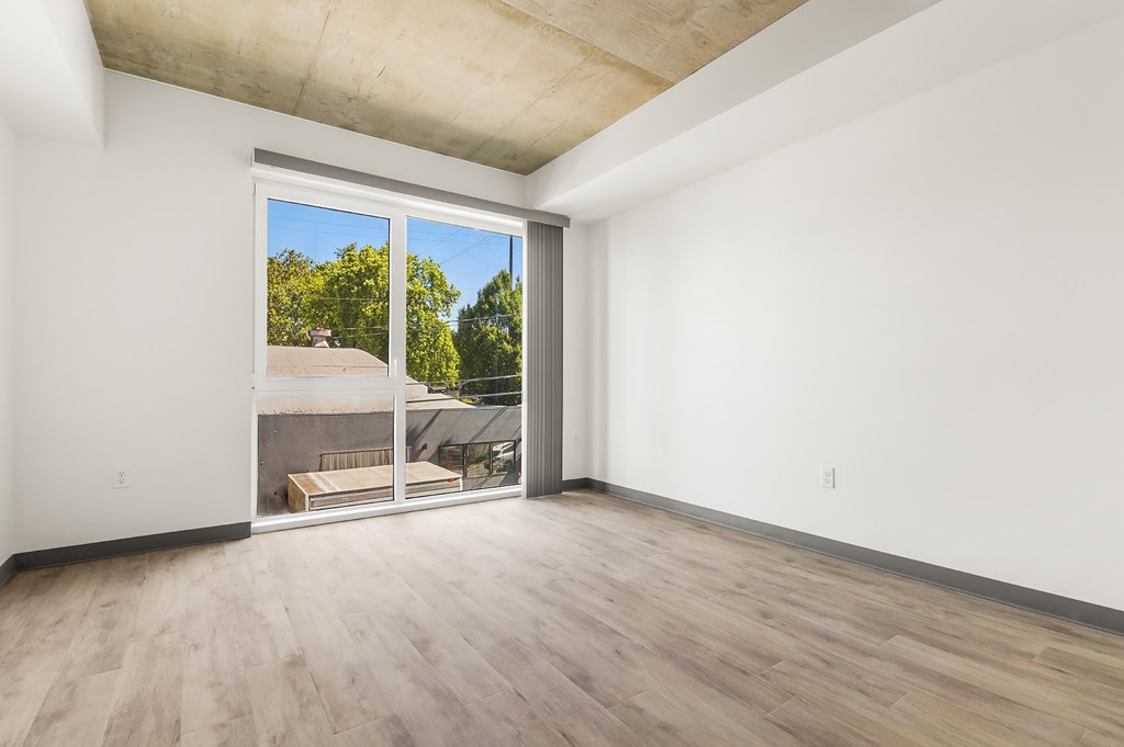 A room with a sliding glass door leading to a backyard.