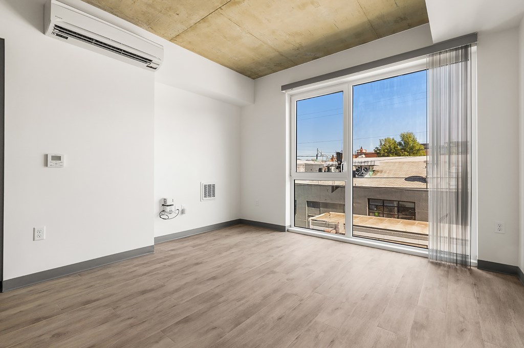 A room with a sliding glass door leading to a balcony.