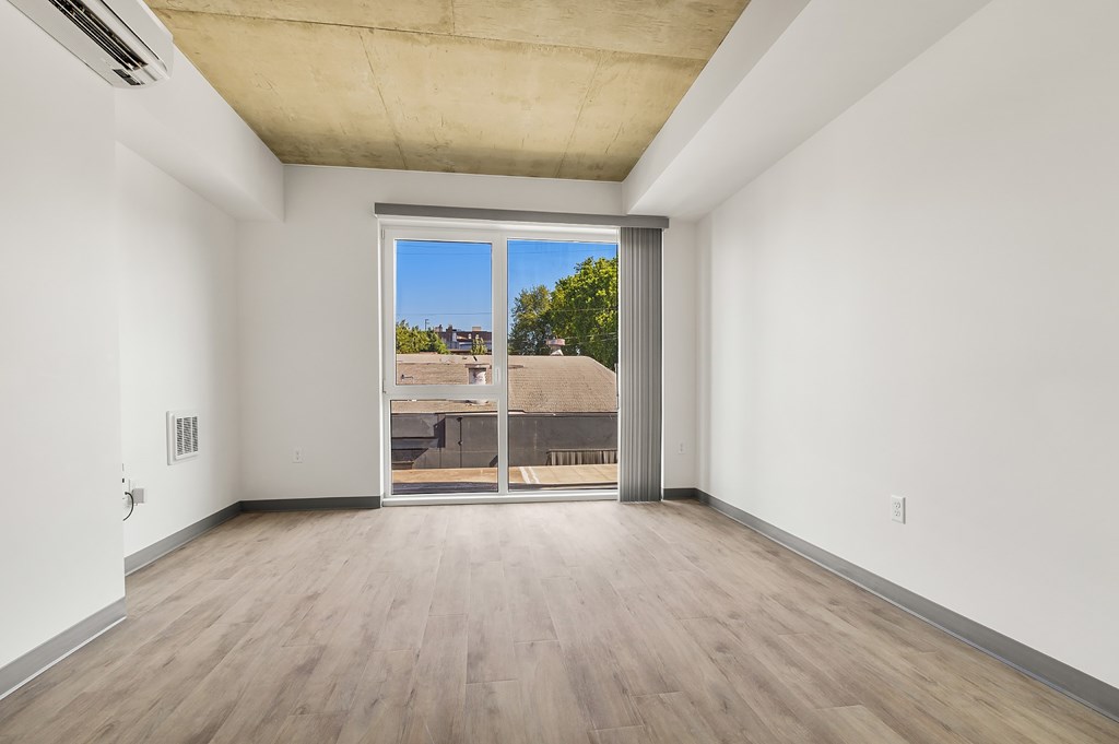 A room with a sliding glass door leading to a balcony.