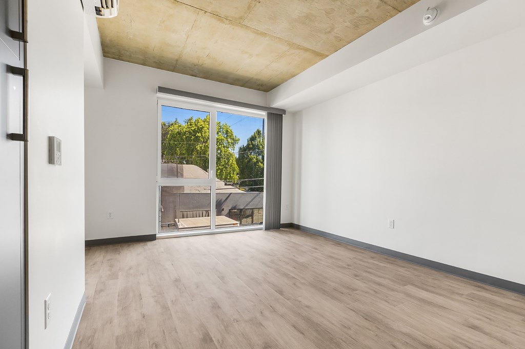 A room with a sliding glass door leading to a backyard.