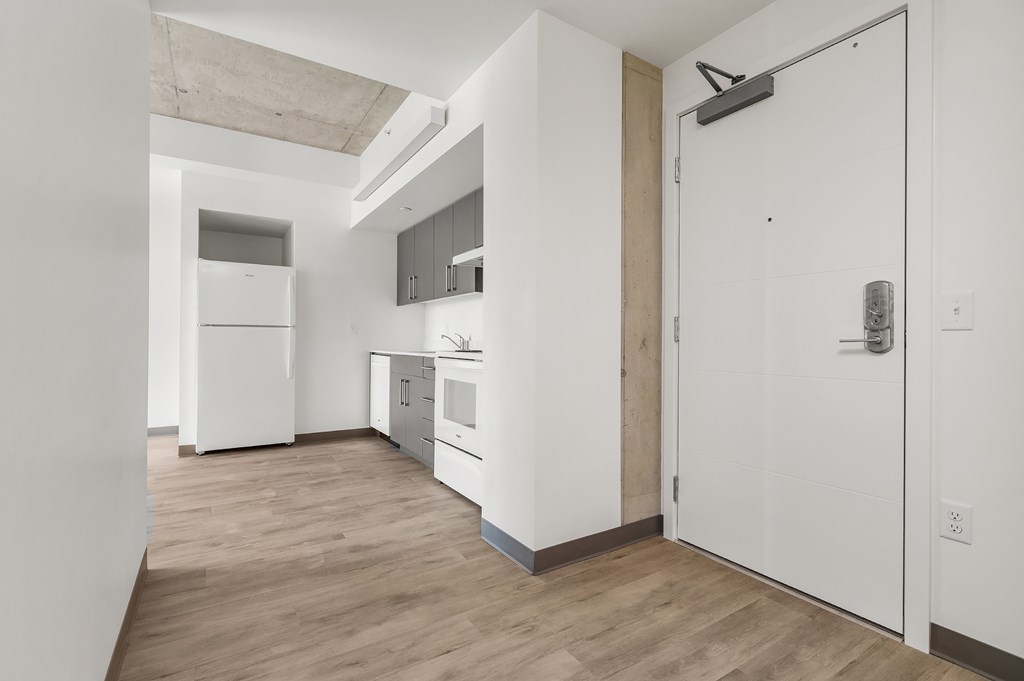 A kitchen with white appliances and wooden floors.