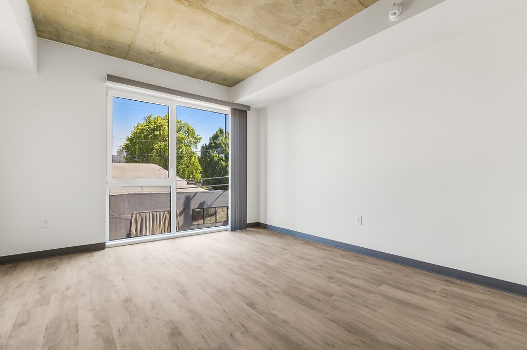 A room with a sliding glass door leading to a backyard.