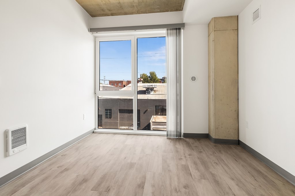 A room with a sliding door leading to a balcony.