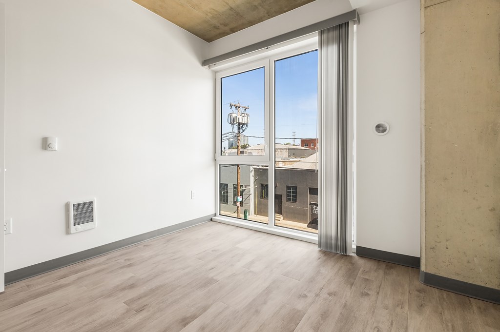 A room with a sliding glass door leading to a balcony.
