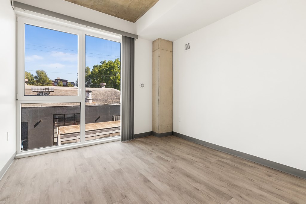 A room with a sliding glass door leading to a balcony.