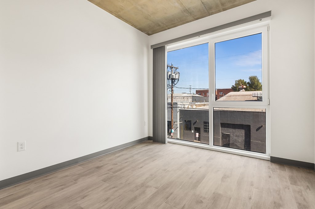 A room with a fireplace and a view of the outside through a large window.
