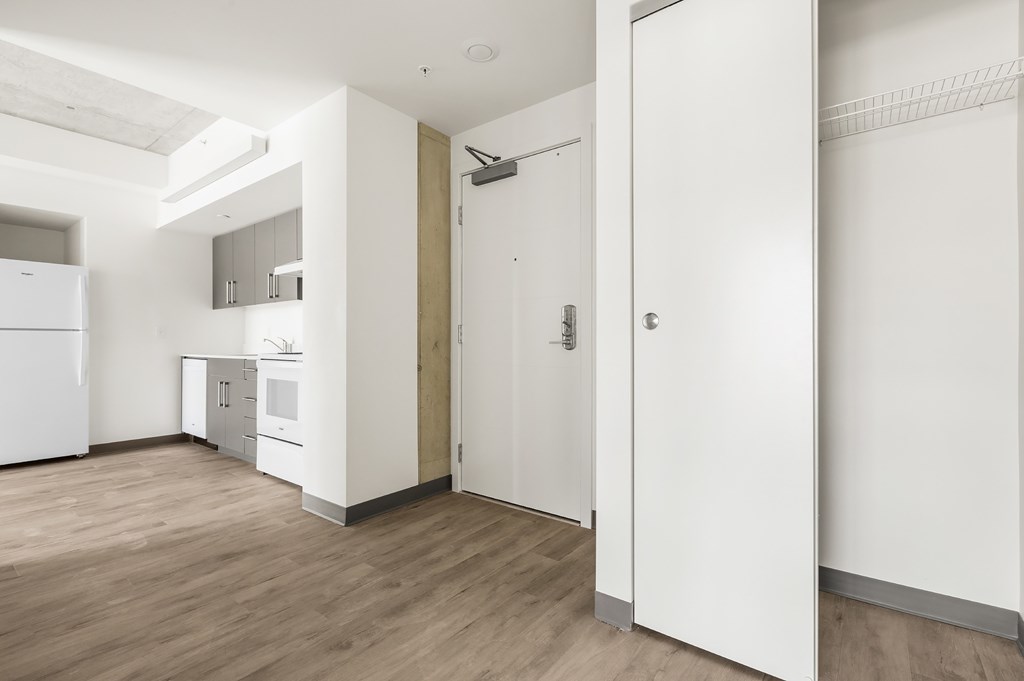 A kitchen with white appliances and a white door.