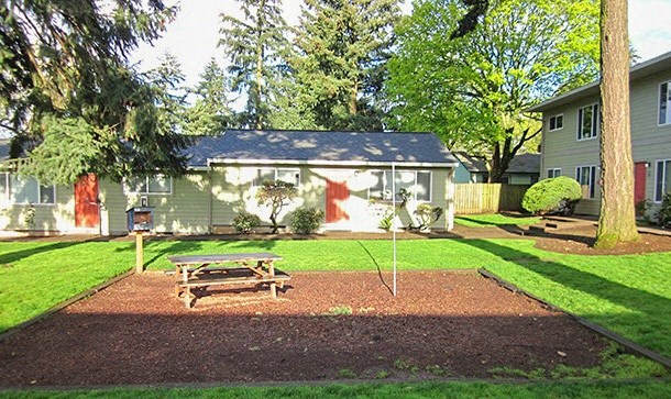 a picnic table in a yard in front of a house