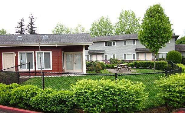 a house with a yard and a fence in front of it