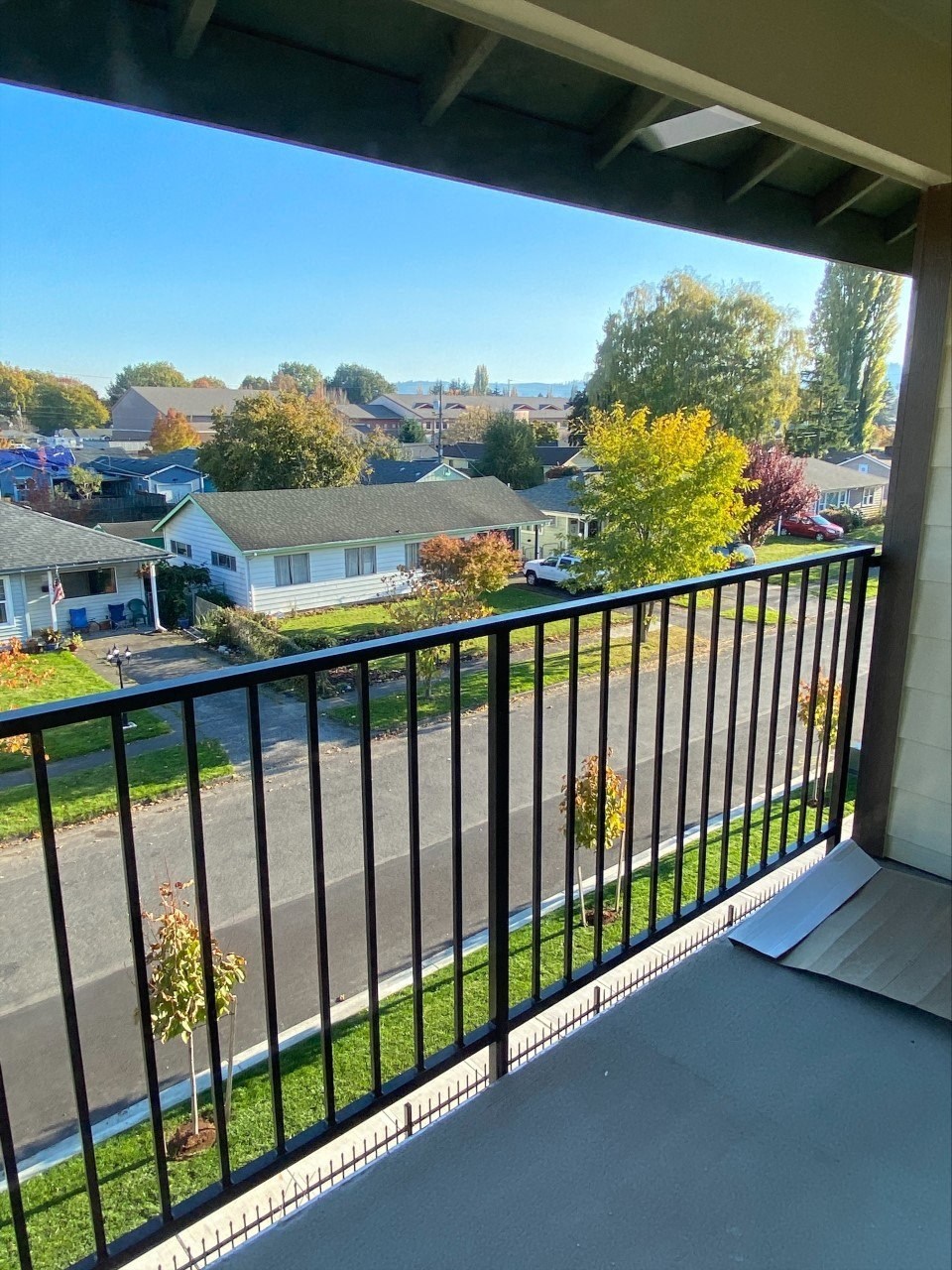 a balcony with a view of a neighborhood and a balcony guard rail