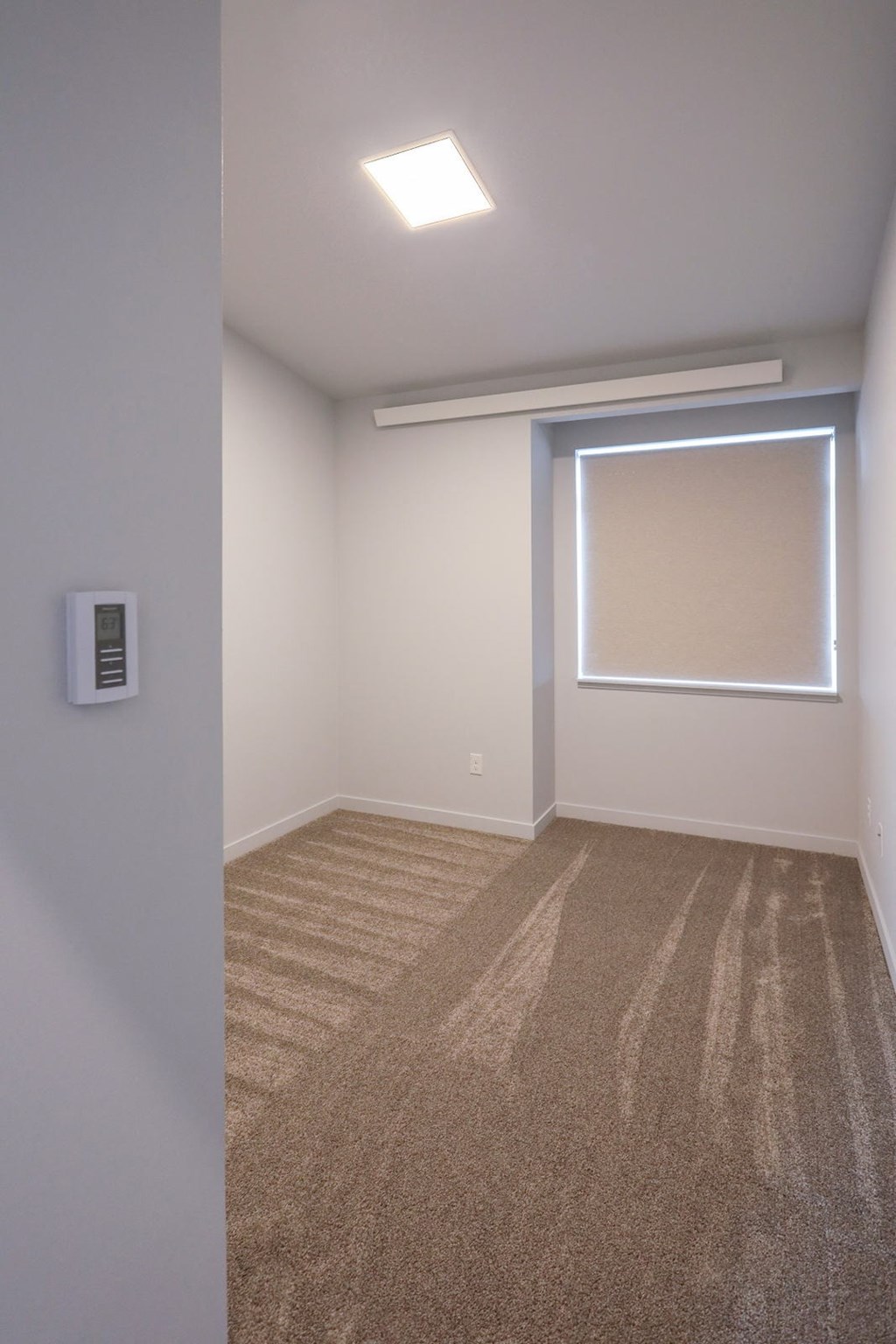 a empty room with carpet and a window