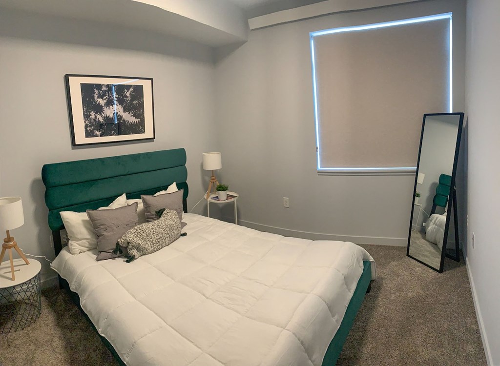 a bedroom with a large bed and a mirror