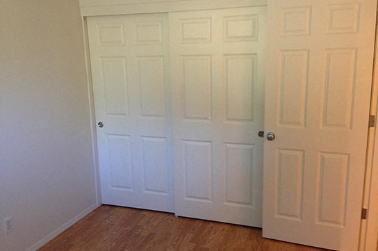 two white doors in a room with a wood floor