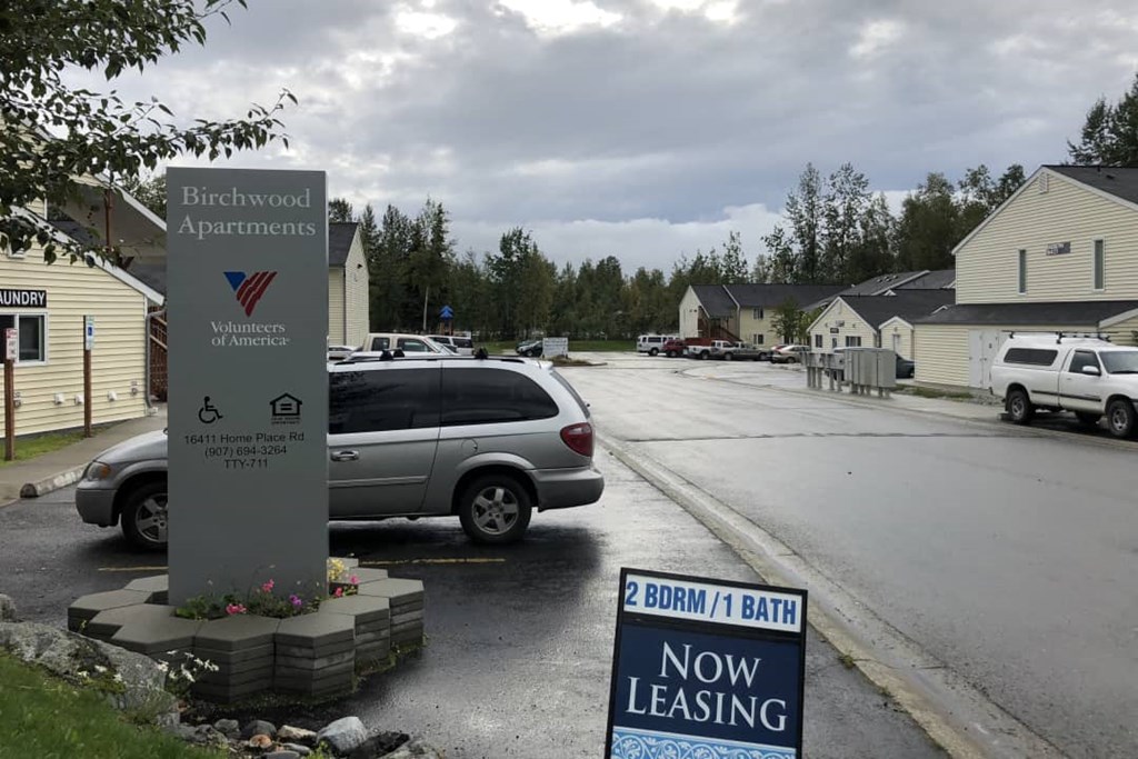 a car parked in a parking lot next to a sign