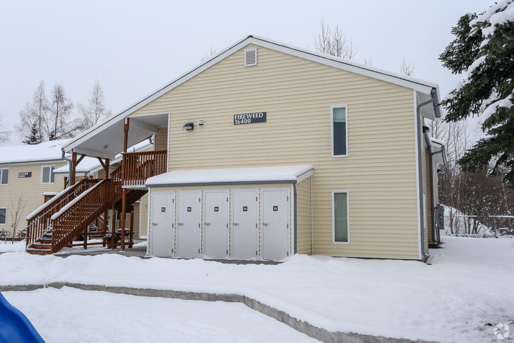 a house with a garage and a staircase in the snow