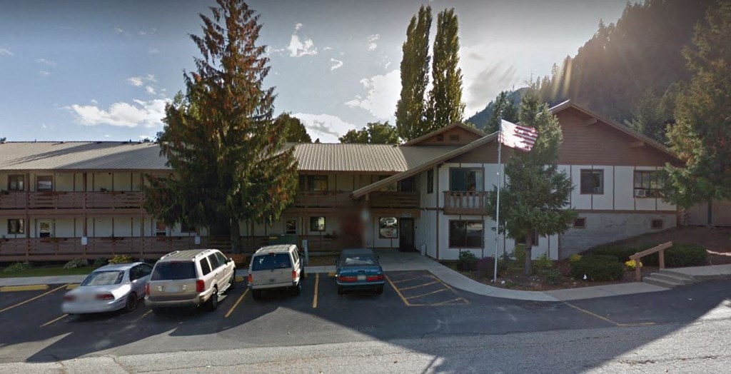 an image of a building with cars parked in a parking lot