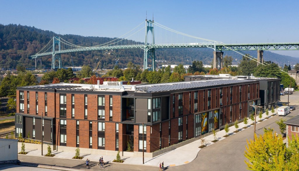 a building with a suspension bridge in the background
