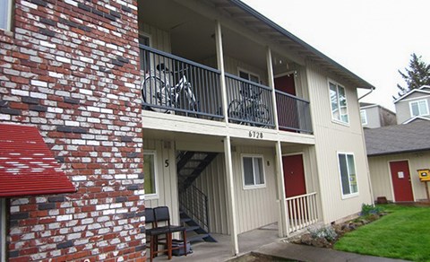 A red brick building with a balcony and a bicycle on it.
