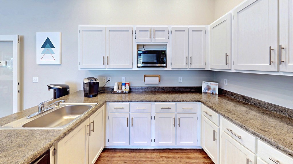 a kitchen with white cabinets and granite counter tops