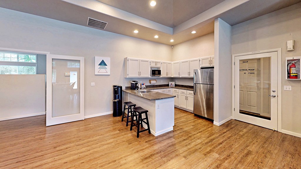a kitchen with an island and a stainless steel refrigerator
