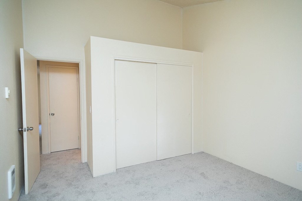 a bedroom with white walls and a white door