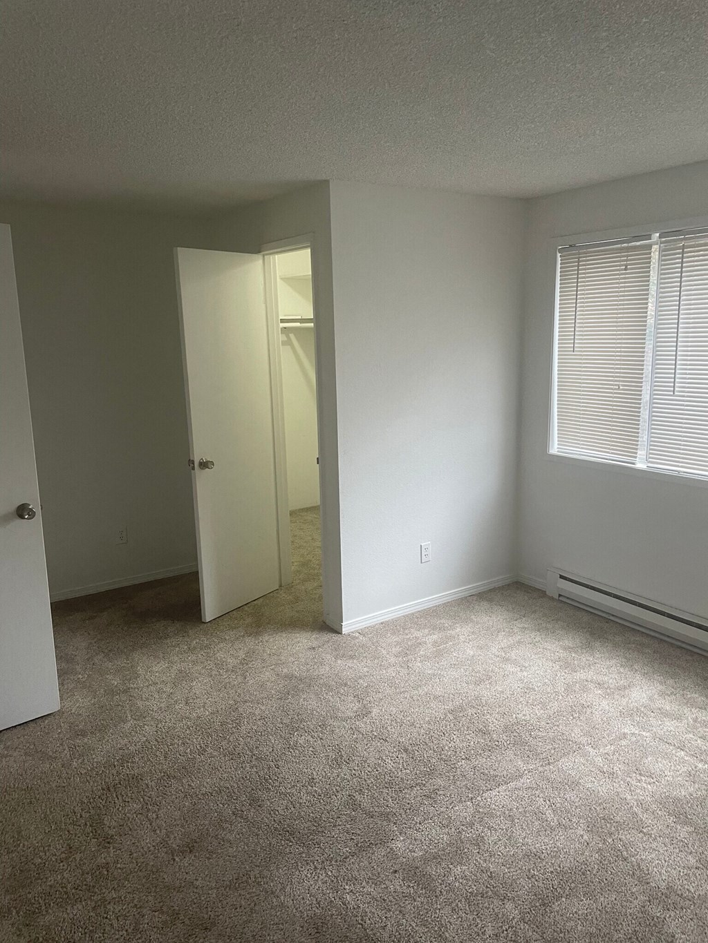 an empty room with a large window and an open door