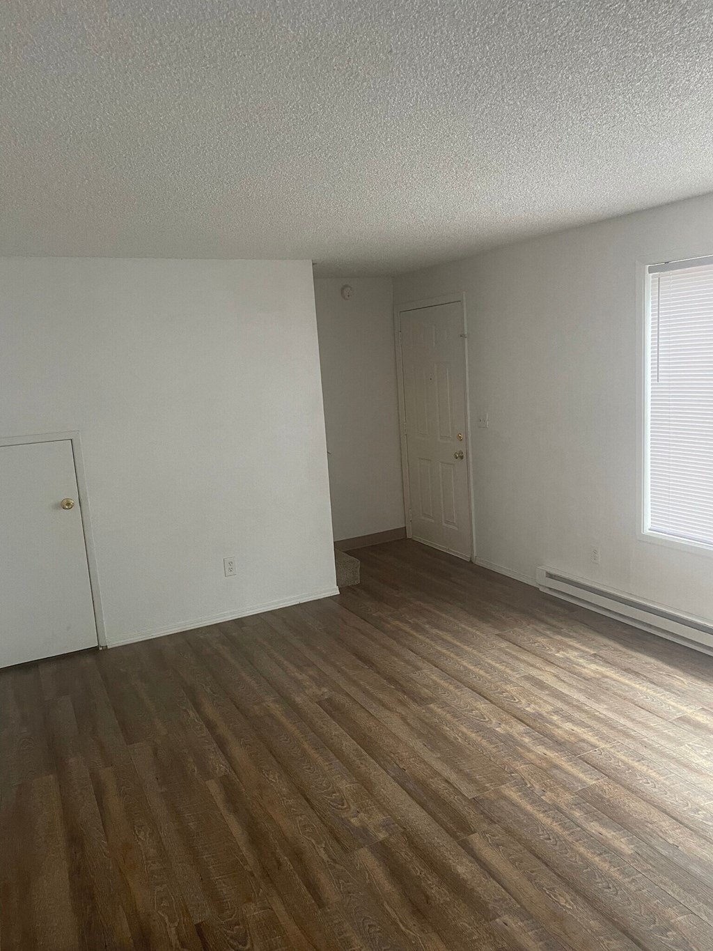 an empty bedroom with a door and a window