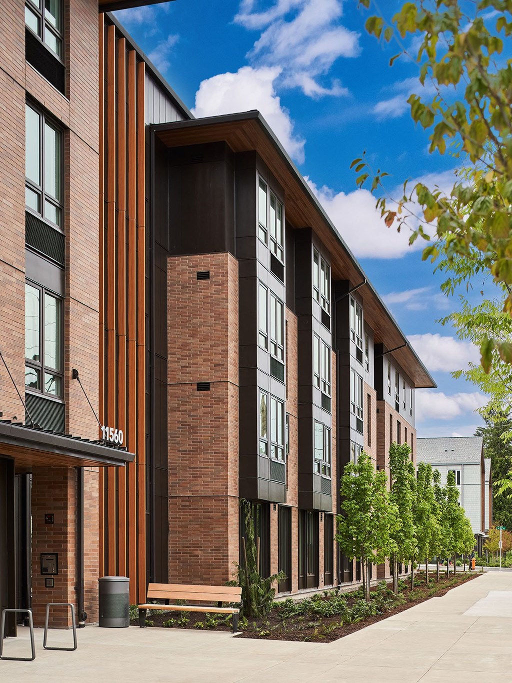 a building with a sidewalk and trees in front of it