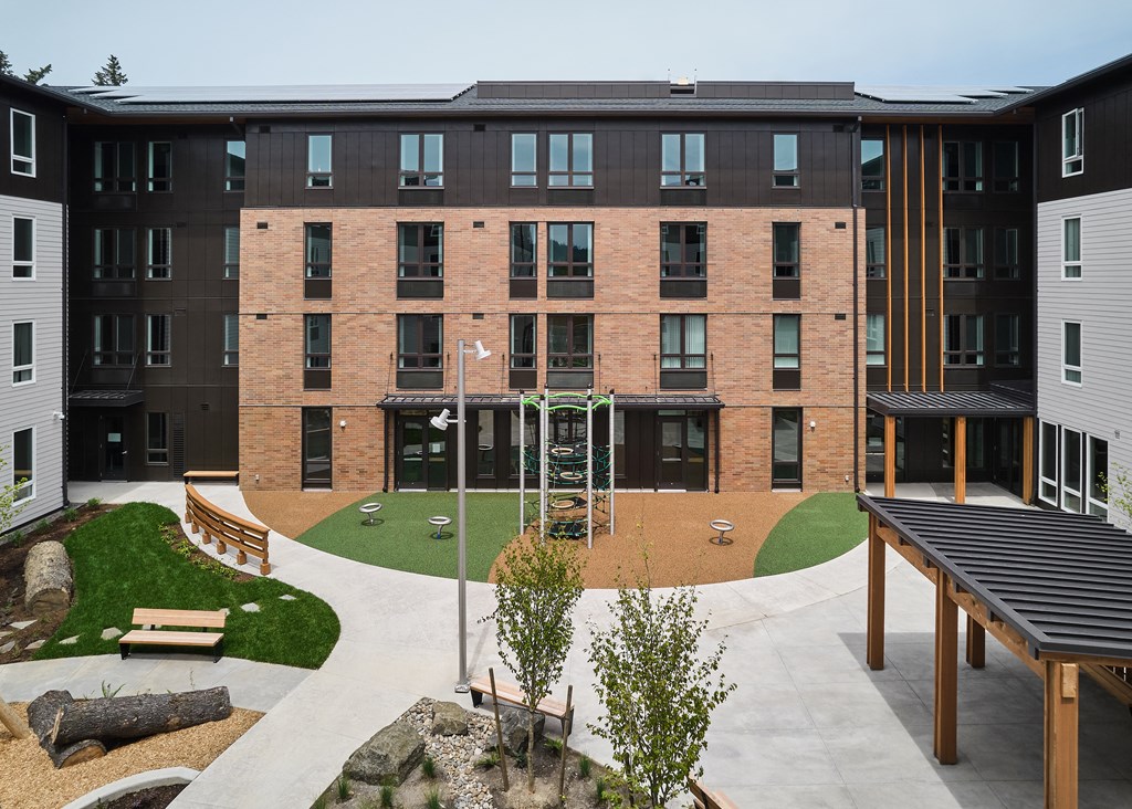a large brick building with a courtyard in front of it
