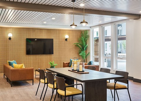 a conference room with a table and chairs and a television