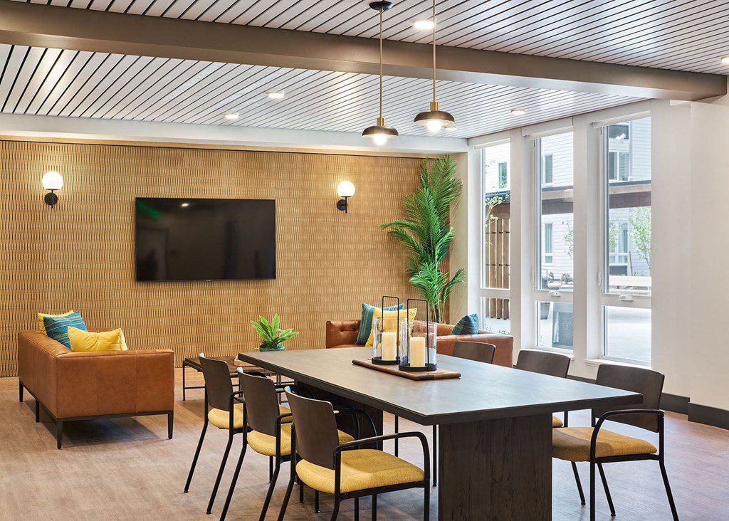 a conference room with a table and chairs and a television