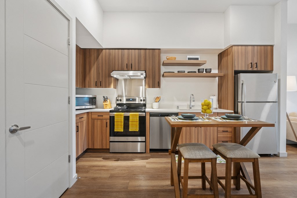a kitchen with wooden cabinets and a table with two stools