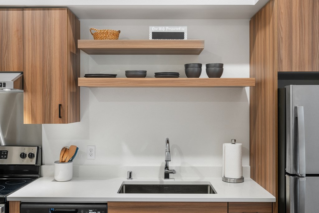 a kitchen with a sink and a refrigerator and wooden cabinets