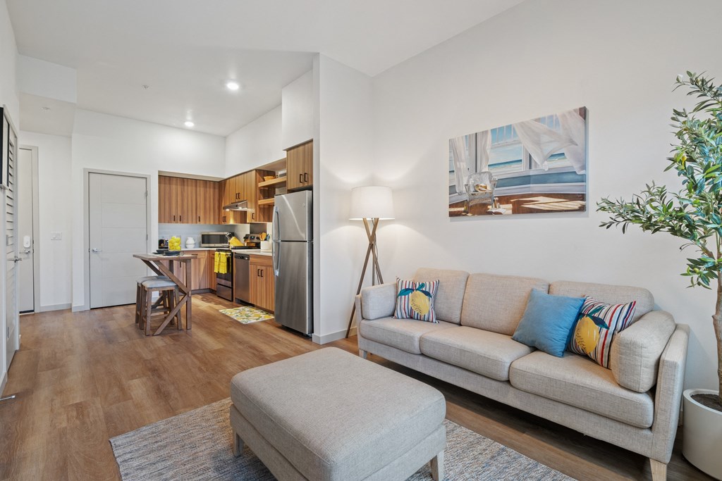 a living room with a couch and a chair and a kitchen