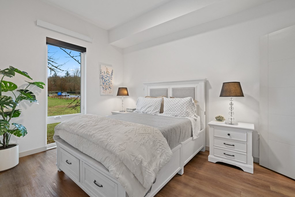 a white bedroom with a bed and a large window
