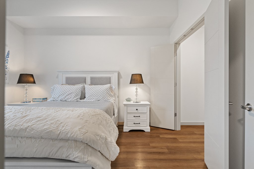 a bedroom with a bed and a nightstand with two lamps