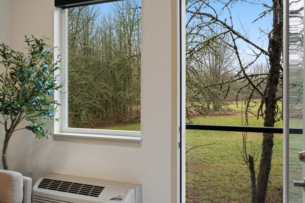 a window with a view of a field and trees