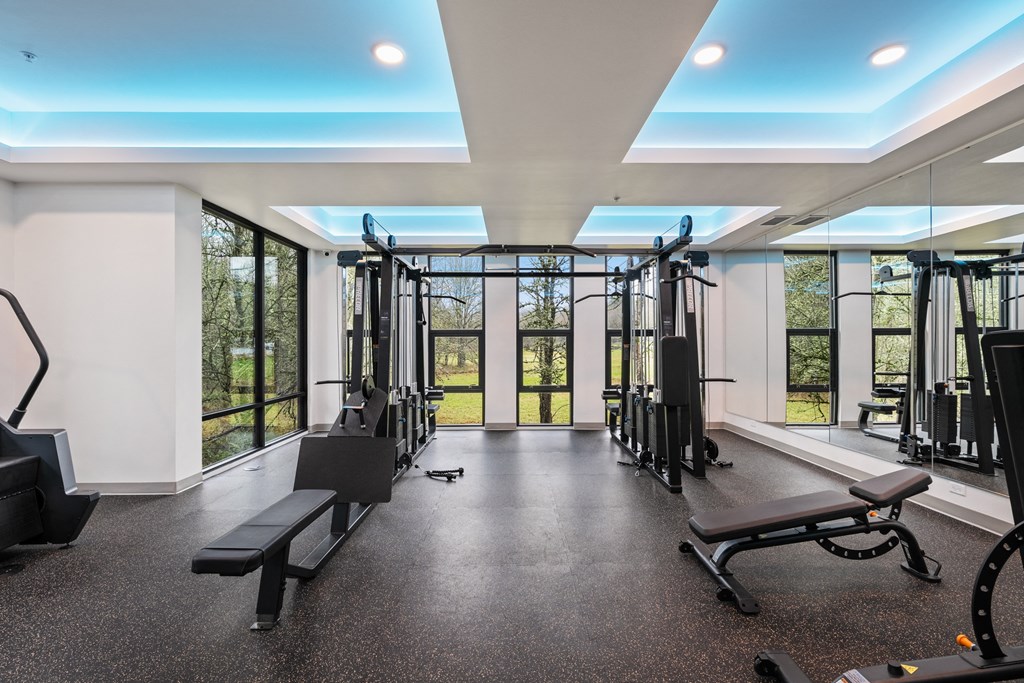 a gym with exercise equipment and windows in a building with glass doors